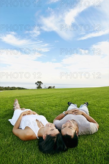 Couple laying in grass in rural landscape