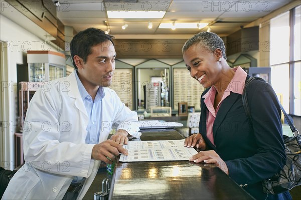 Optometrist talking to patient in office