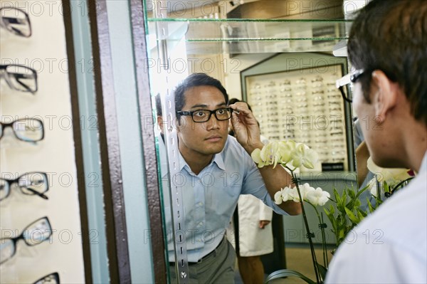 Filipino man trying on glasses at optometrist