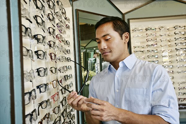 Filipino man trying on glasses at optometrist