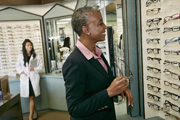 Black woman trying on glasses at optometrist