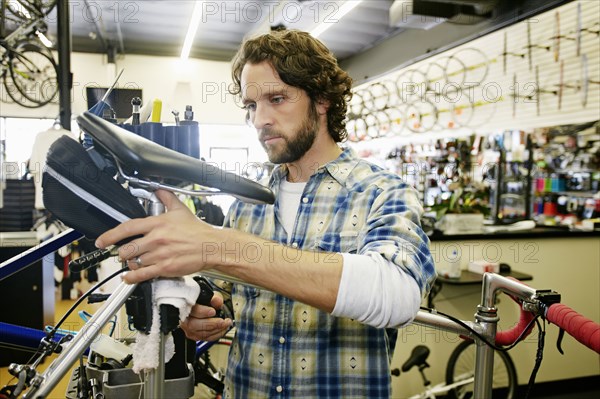 Caucasian man smiling in bicycle repair shop