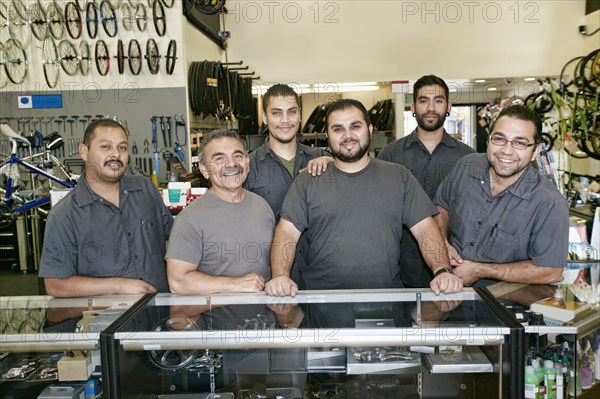 Mechanics smiling in bicycle repair shop