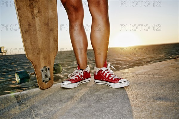 Woman holding longboards on beach