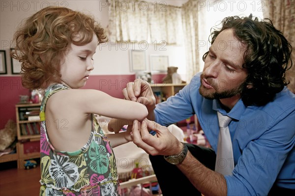 Caucasian father examining daughter's scrape