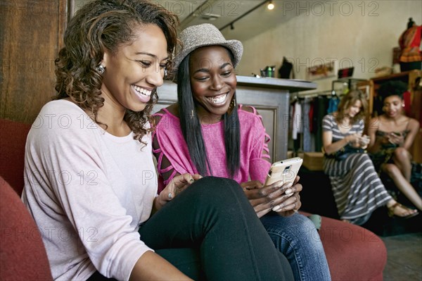 Women using cell phone in store