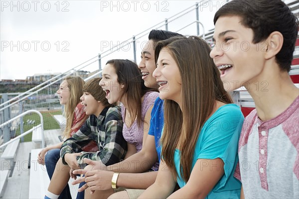 Teenagers watching game from bleachers