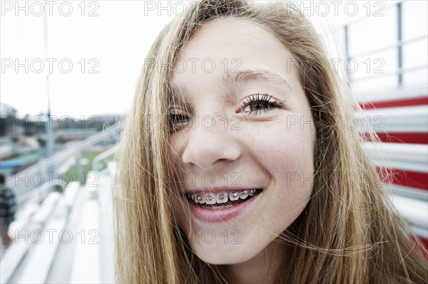 Teenage girl smiling on bleachers