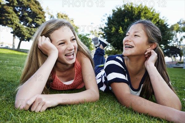 Teenage girls laying in grass