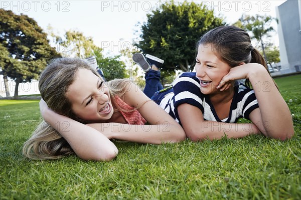 Teenage girls laying in grass