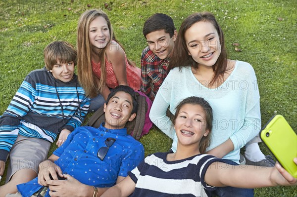 Teenagers taking picture together in grass