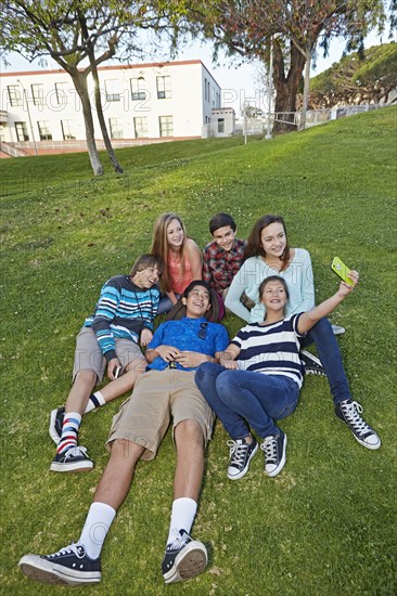 Teenagers taking picture together in grass