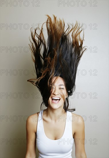 Mixed race woman tossing her hair