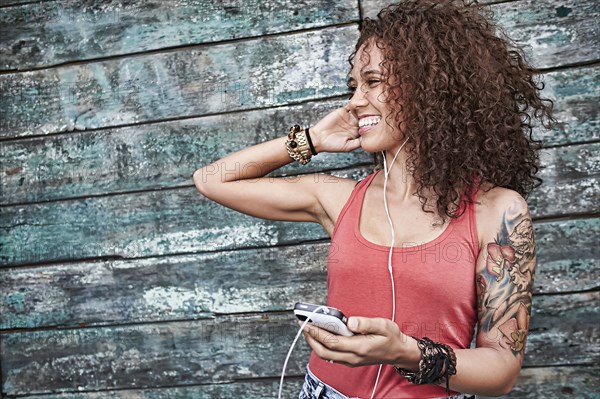 Woman listening to mp3 player on city street