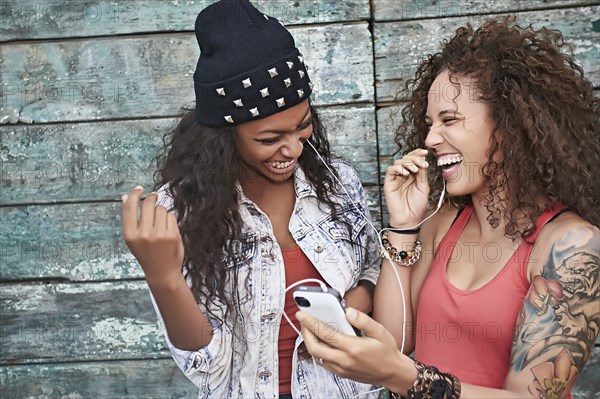 Women listening to mp3 player on city street