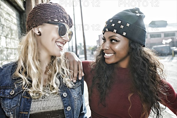 Women smiling together on city street