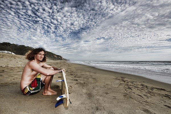 Caucasian man holding surfboard on beach