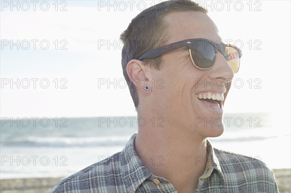 Caucasian man laughing on beach