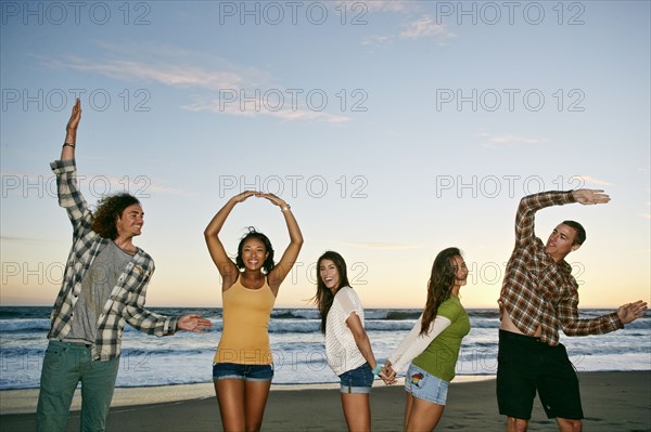 Friends spelling Love on beach