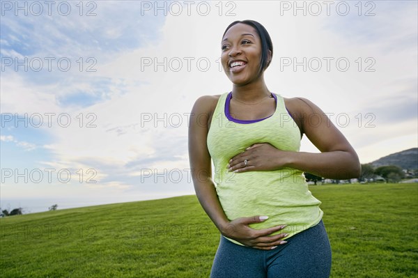 Pregnant woman laughing in park