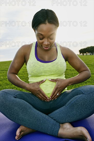 Pregnant woman holding her stomach in park