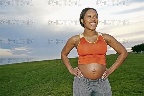 Pregnant woman smiling in park