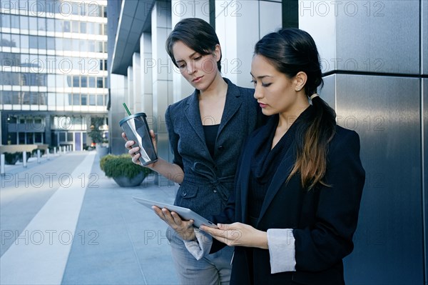 Businesswomen using tablet computer in city