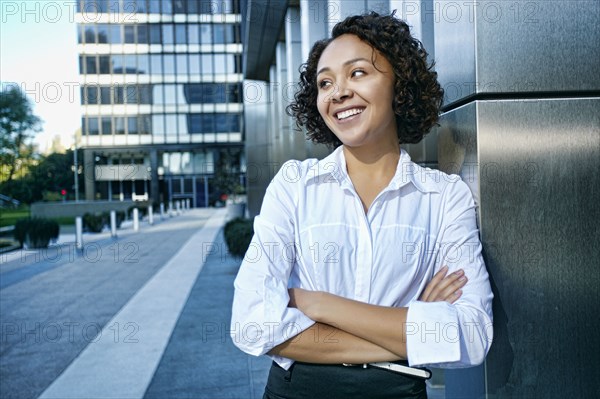 Mixed race businesswoman standing in city