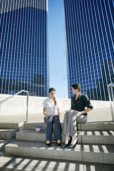 Businesswomen talking on city staircase