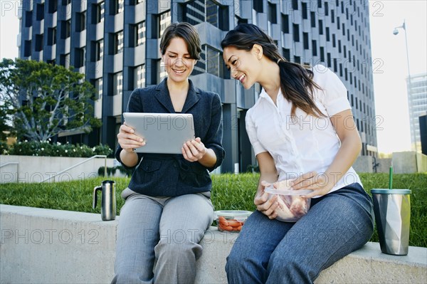 Businesswomen using tablet computer in city