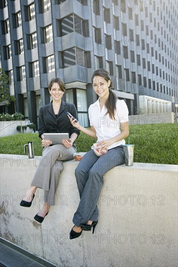 Businesswomen using tablet computer in city