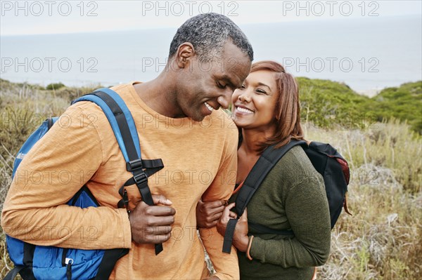 Black couple hiking on rural hillside