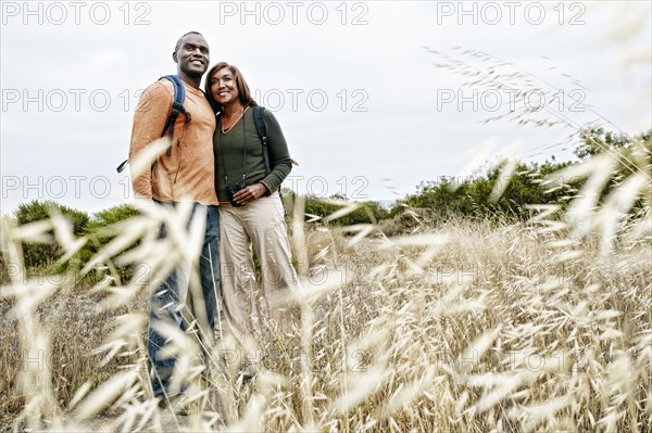 Black couple smiling on rural hillside