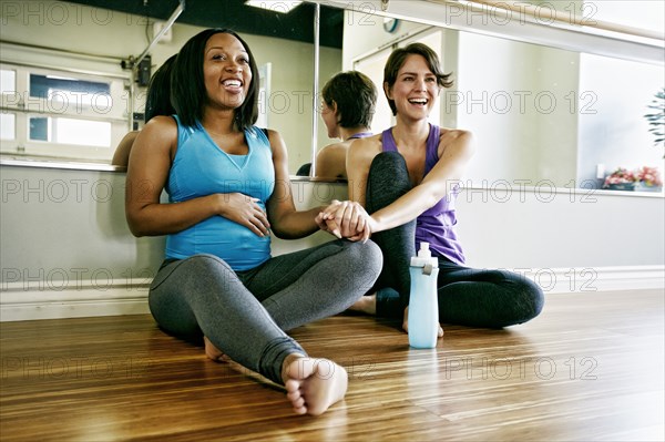 Women holding hands in yoga studio