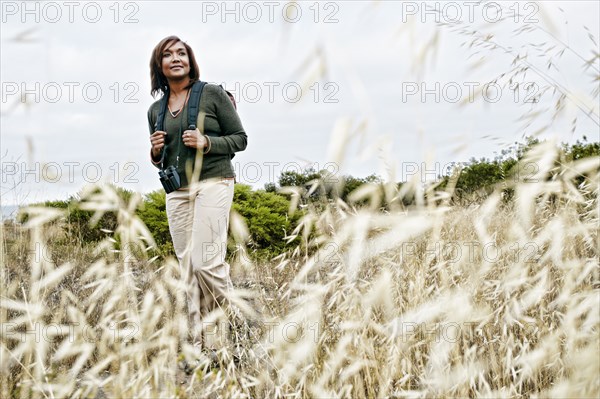 Black woman hiking on rural hillside