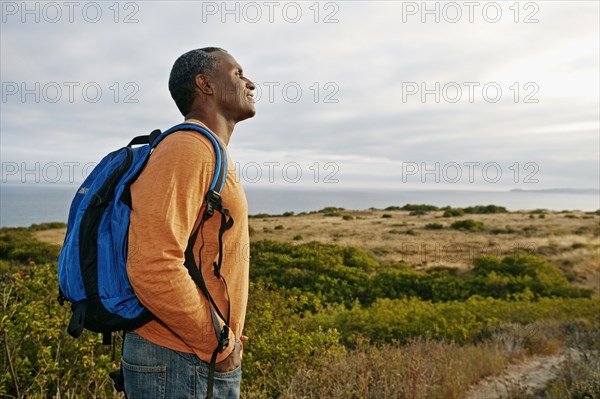 Black man overlooking rural hillside