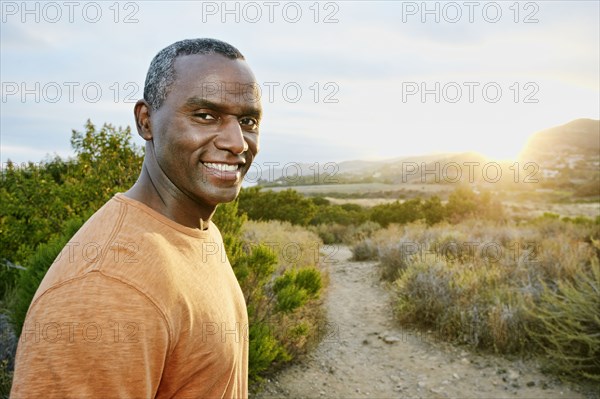 Black man smiling on rural hillside