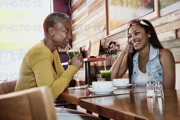 Mother and daughter drinking juice in cafe