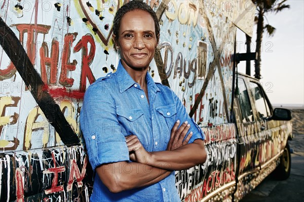 Older Black woman standing by decorated truck