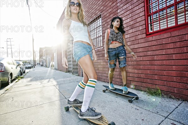 Women riding skateboards on city street