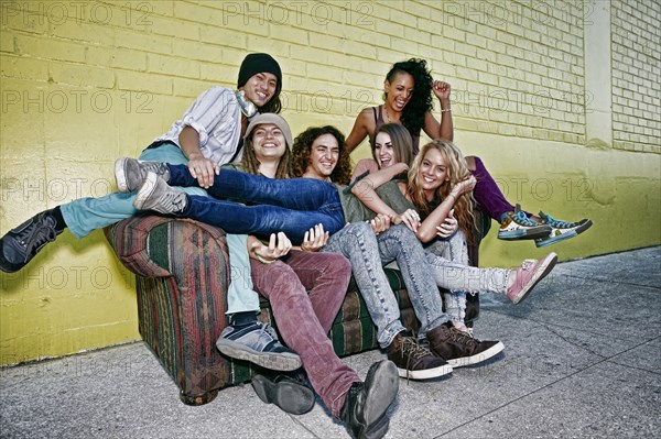 Friends relaxing on sofa on city street