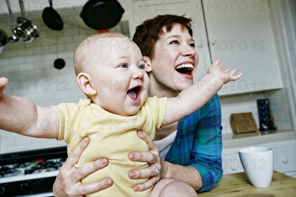 Caucasian mother and baby relaxing in kitchen