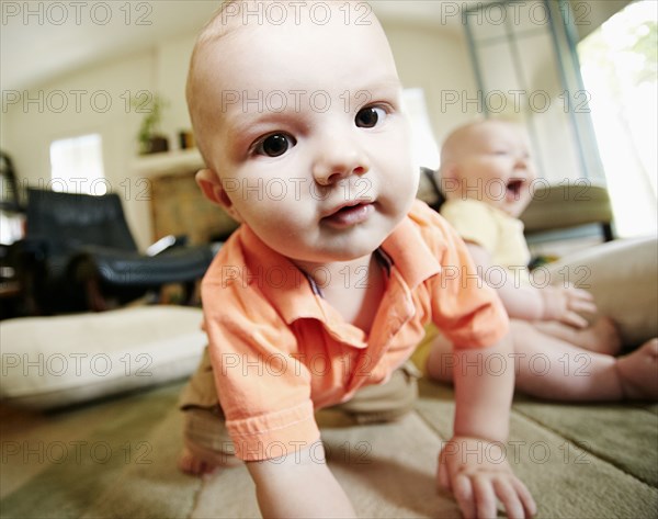 Caucasian baby crawling on living room floor