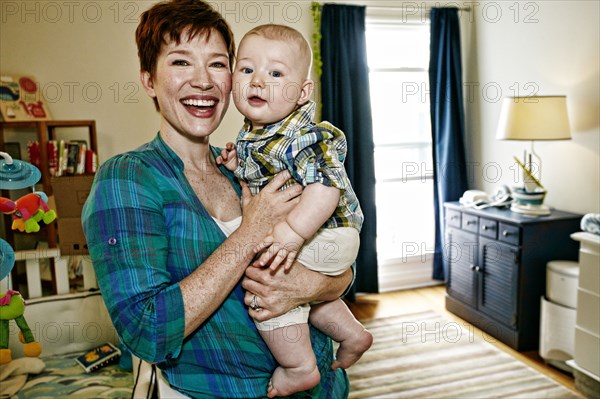 Caucasian mother holding baby in bedroom