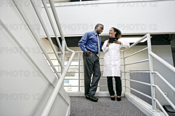 Doctor and businessman using digital tablet together