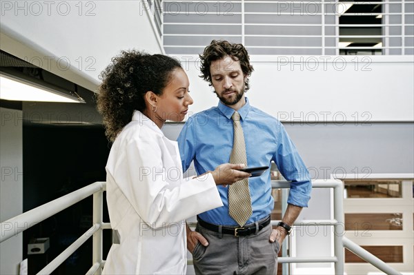 Doctor and businessman using digital tablet together