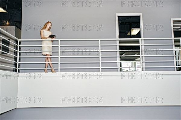 Caucasian businesswoman using digital tablet railing