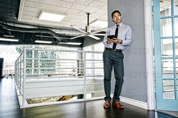 Chinese businessman using digital tablet outside office