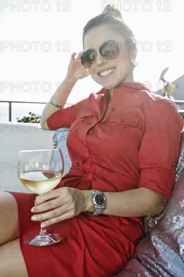 Mixed race woman drinking white wine