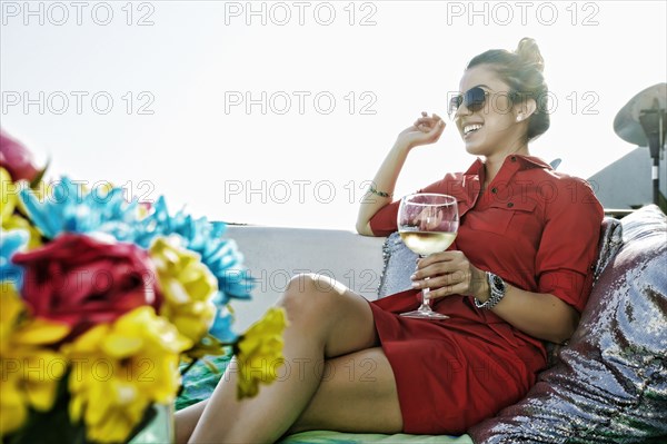 Mixed race woman drinking white wine